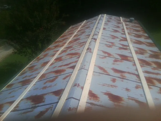Rusted metal roof panels with new wood purlins before replacement — Storm Damage Roof Repair in Lamoure by Roofing Brothers